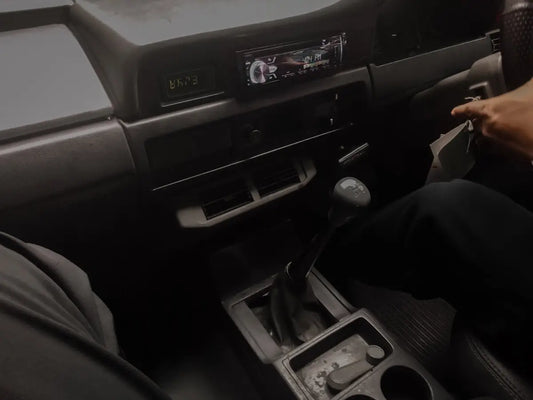 a person sitting in a car with a steering wheel