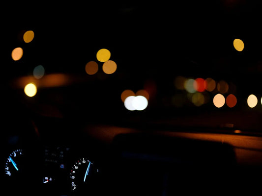 The dashboard of a car at night with blurry lights