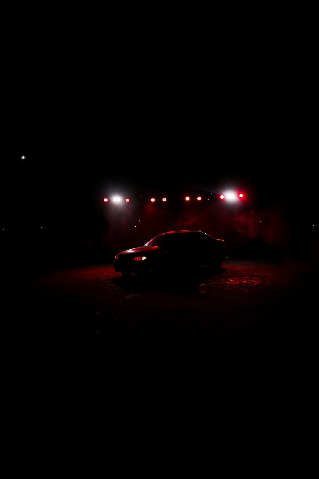 A car is illuminated by lights at night.