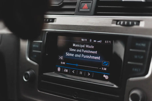 a car dashboard with a radio and a remote control