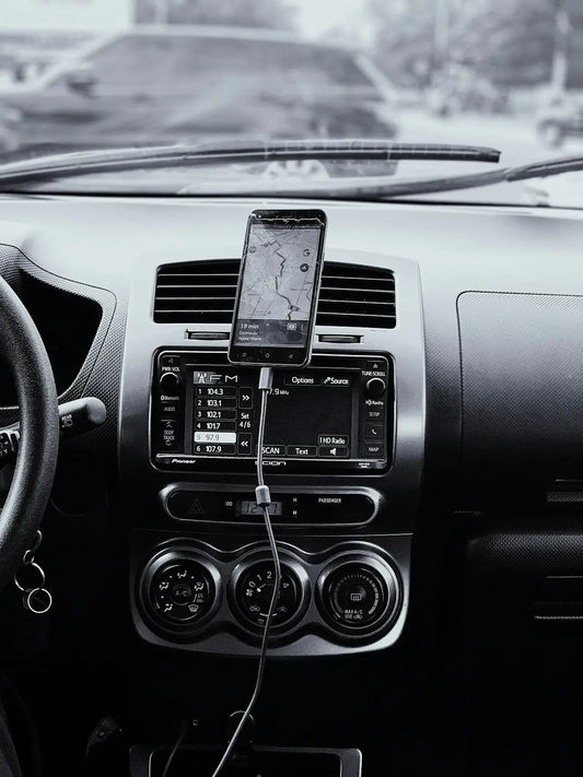 black car stereo turned on in grayscale photography