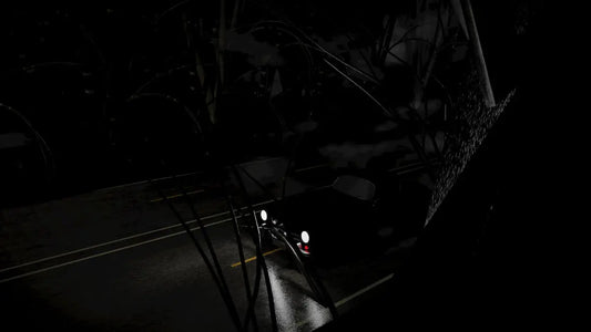 A car driving down a dark street at night