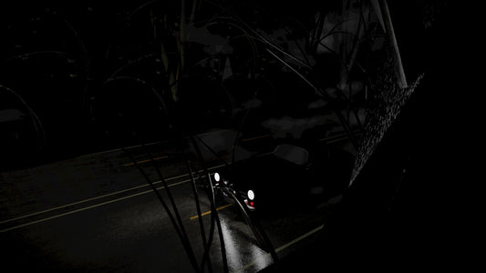 A car driving down a dark street at night