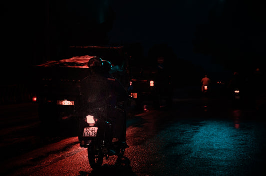 a man riding a motorcycle down a street at night