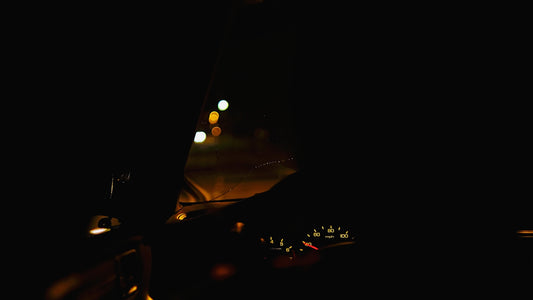 a car driving down a street at night