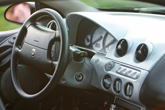 a car dashboard with a steering wheel and a dash board