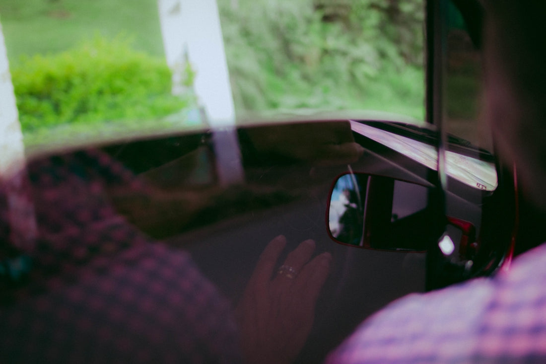 a man driving a car while holding a cell phone