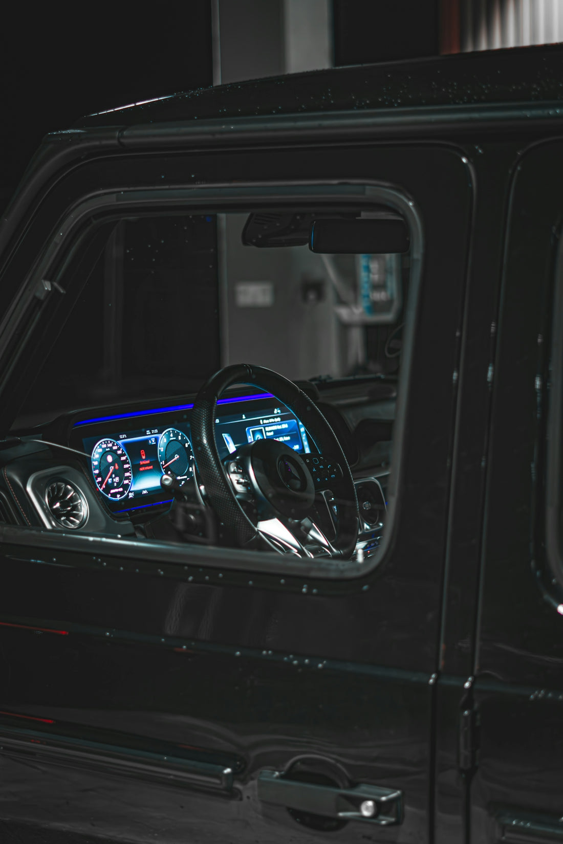 the interior of a black jeep with a blue dash light
