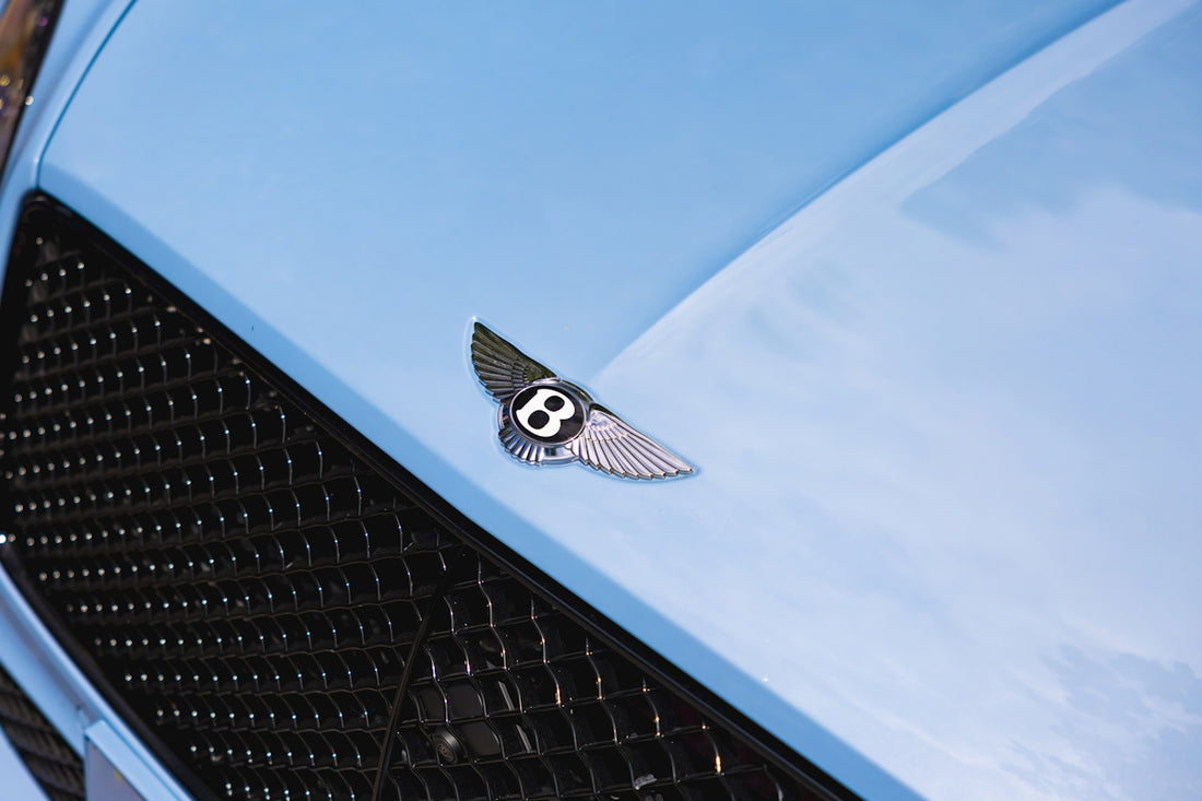 a close up of a bentley emblem on a blue car