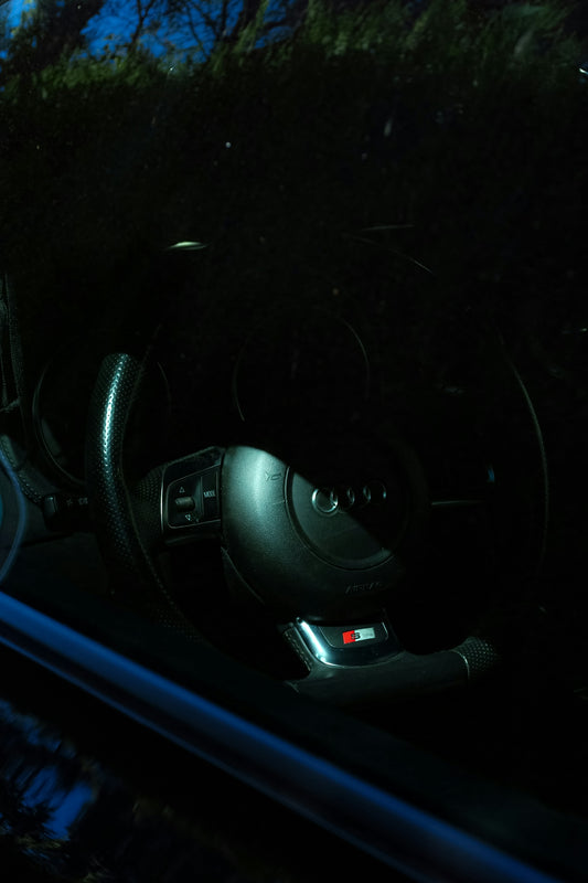 The interior of a car with a steering wheel and dashboard