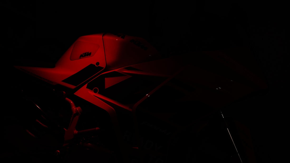 A red light shining on a motorcycle in the dark