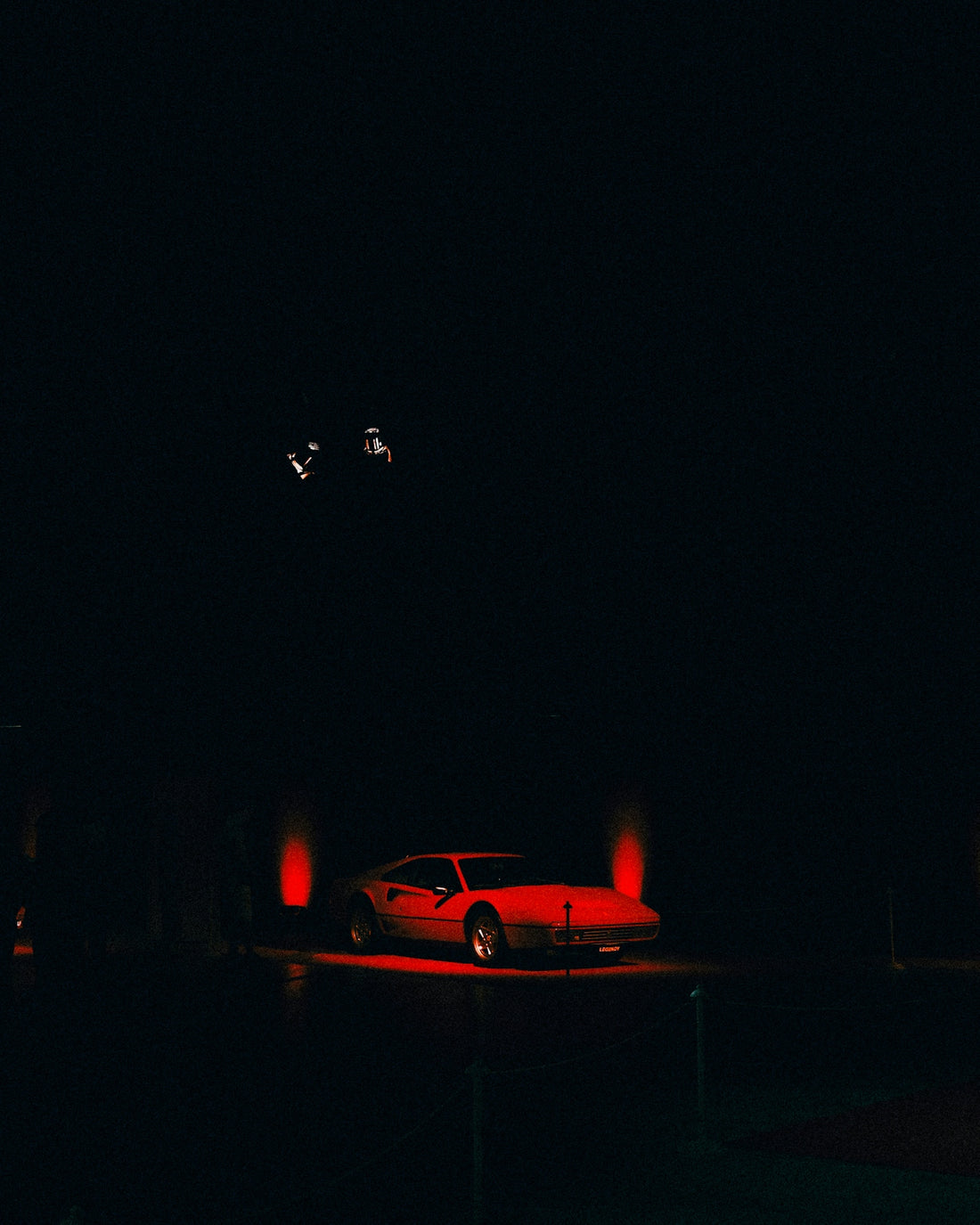 Red car illuminated at night.