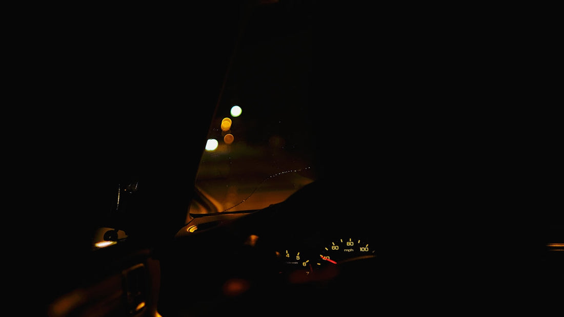 a car driving down a street at night